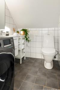 a white bathroom with a toilet and a sink at Dinbnb Apartments I 100 meters from Bryggen I Self check-in I Coffee + in Bergen