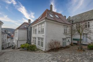 a white house with a red roof on a street at Dinbnb Apartments I 100 meters from Bryggen I Self check-in I Coffee + in Bergen