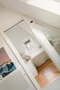 a white room with a bed and a window at Dinbnb Apartments I 100 meters from Bryggen I Self check-in I Coffee + in Bergen