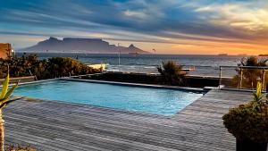een zwembad met uitzicht op de oceaan bij Heaven on Earth - Blouberg Beachfront Self-catering Apartment in Bloubergstrand