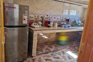 una cucina con frigorifero in acciaio inossidabile e bancone di دار الياقوت Dar Al Yaqut a Dakhla