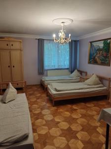 sypialnia z 2 łóżkami i żyrandolem w obiekcie Willa Wiekowa Sosna w mieście Zalesie Górne