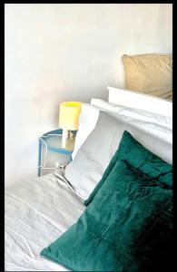 Una cama blanca con una manta verde encima. en A best area Palace-Sol- Gran Vía, en Madrid