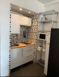 una pequeña cocina con armarios blancos y fregadero en A best area Palace-Sol- Gran Vía, en Madrid