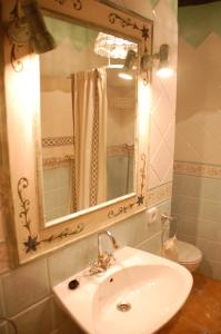uma casa de banho com um lavatório, um espelho e um WC. em Cal Balico Fatarella em Fatarella