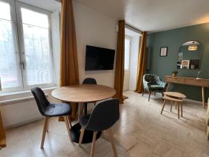 een woonkamer met een tafel en stoelen bij Beau F2 rénové au coeur de Caen in Caen