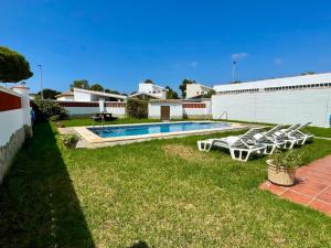a yard with a pool and a group of lounge chairs at Chalet Manku in Chiclana de la Frontera