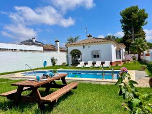 a backyard with a picnic table and a swimming pool at Chalet Manku in Chiclana de la Frontera