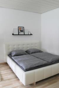 ein Bett in einem Schlafzimmer mit einer weißen Wand in der Unterkunft Stilvolle Wohnungen im Villenviertel Villachs in Villach