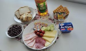 a table with a plate of food with cheese and meats at Hotel Orka in Moravská Třebová