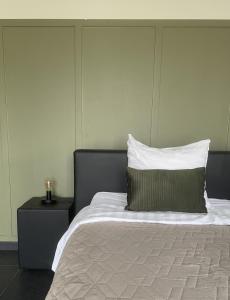 a bedroom with a bed with a pillow and a nightstand at Gasterij de Heihorst in Someren