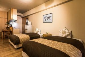 um quarto de hotel com duas camas e um frigorífico em Residence Hotel Naha West em Naha