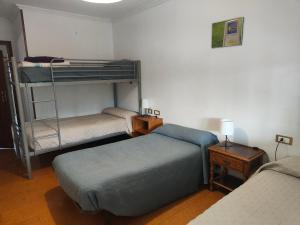 Cette chambre comprend 2 lits superposés et une table. dans l'établissement QUINTA ANDAINA, à Sigüeiro