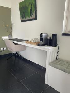 een wit bureau met een stoel in een kamer bij B&B Gasterij de Heihorst in Someren