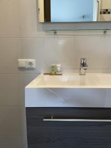 a bathroom with a white sink and a mirror at Gasterij de Heihorst in Someren
