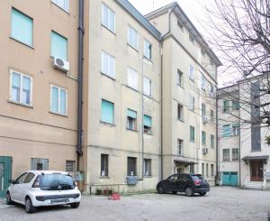 twee auto's geparkeerd op een parkeerplaats voor een gebouw bij Dandolo apartment by Welc(h)ome in Treviso