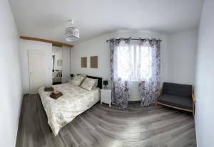 1 dormitorio con 1 cama, 1 silla y 1 ventana en Les Villas de Castel - Villa Les lauriers, en Castelmaurou