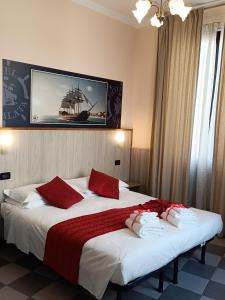 ジェノヴァにあるホテル ガラタのホテルルーム ベッド2台 赤い枕付