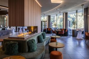 a hotel lobby with a fireplace and tables and chairs at Sporthotel Wagrain in Wagrain