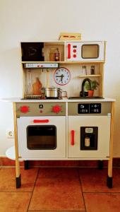 une cuisine jouet avec une cuisinière et un micro-ondes factices dans l'établissement Familienfreundliches modernes Ferienhaus nahe zum Meer und zur Pier, à Heringsdorf 8 autres photos