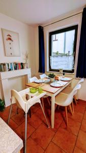 une salle à manger avec une table et des chaises et une fenêtre dans l'établissement Familienfreundliches modernes Ferienhaus nahe zum Meer und zur Pier, à Heringsdorf