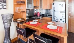 eine Küche mit einem Tisch mit Stühlen und einem Kühlschrank in der Unterkunft Departamento en Centro Providencia in Santiago