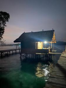 una casa su un molo con una luce sull'acqua di I&D Home Stay Raja Ampat a Yennanas Besir