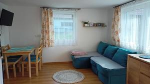 een woonkamer met een blauwe bank en een tafel bij Mogielicki Zakątek in Jurków