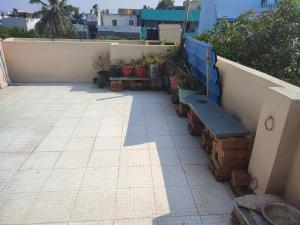 un patio con un banco junto a una pared con plantas en Blue Diamond, en Chennai