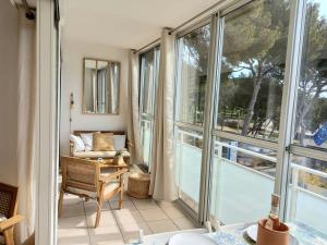 Cette chambre dispose de grandes fenêtres et d'un balcon avec une chaise. dans l'établissement T2 - Centre ville - proche plage, à Bormes-les-Mimosas