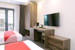 ein Hotelzimmer mit einem Bett und einem Schreibtisch mit einem TV in der Unterkunft Hạ Long Legend Hotel in Hạ Long