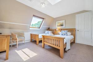 um quarto com 2 camas, uma secretária e uma janela em Alice Howe em Windermere