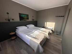 a bedroom with a large bed with white sheets and pillows at Klara Guesthouse in Ólafsfjörður