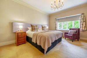 a bedroom with a bed and a chair and a window at Number One in Windermere