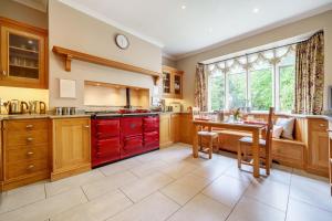a large kitchen with red cabinets and a table at Number One in Windermere