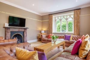 a living room with leather couches and a fireplace at Number One in Windermere