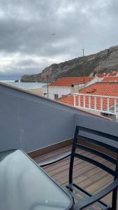 een stoel op een balkon met uitzicht op de oceaan bij Ferhouse Dreams-Farilhões in Nazaré