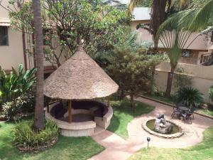 a small garden with a gazebo in the yard at Hotel la chaumiere in Bamako