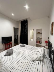 ネットゥーノにあるMiramareのベッドルーム(白い大型ベッド1台、テレビ付)