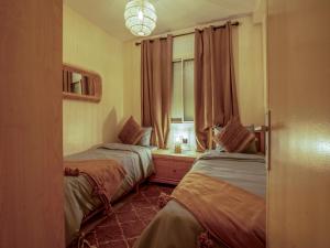 - 2 lits dans une chambre avec fenêtre dans l'établissement ALIYA LUXURY APARTMENT TAMANART 1-AGADIR, à Agadir