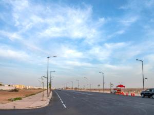 een lege weg met straatverlichting aan de kant van de weg bij ALIYA LUXURY APARTMENT TAMANART 1-AGADIR in Agadir