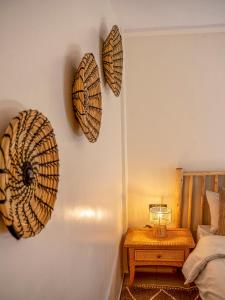 een kamer met een bed en twee hoeden aan de muur bij ALIYA LUXURY APARTMENT TAMANART 1-AGADIR in Agadir