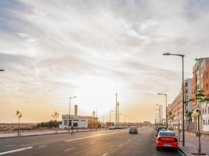 une rue de la ville avec des voitures garées sur la route dans l'établissement ALIYA LUXURY APARTMENT TAMANART 1-AGADIR, à Agadir