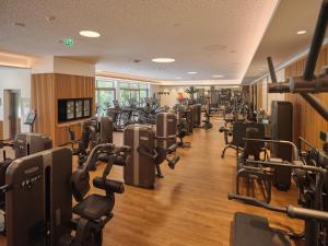 a gym with rows of treadmills and machines at Sporthotel Wagrain in Wagrain