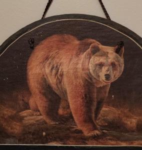una pintura de un oso marrón en un espejo en Talo Kainuun korvessa Kiekinkoskella, en Kuhmo