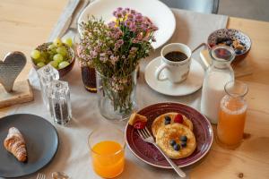 - une table avec des aliments pour le petit-déjeuner et du jus d'orange dans l'établissement Hotel Nevada, à Bormio