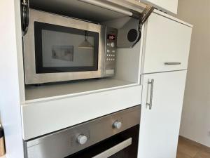 a microwave oven sitting inside of a kitchen at ٤Sweet Spot٤Geräumig-King Bed-Disney+-Parken in Scharbeutz