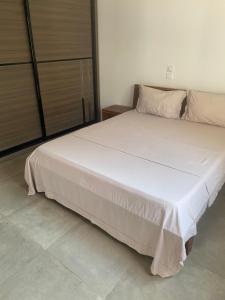 duże białe łóżko w pokoju z: w obiekcie La villa de Michel w mieście Ngaparou
