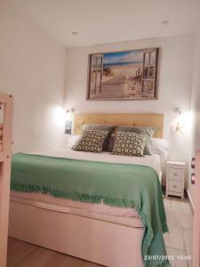 a bedroom with a large bed with a green blanket at Casa La Marina in Alcossebre
