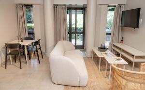 un soggiorno con divano bianco e tavolo di BlackBrick Bedfordview ApartHotel a Johannesburg